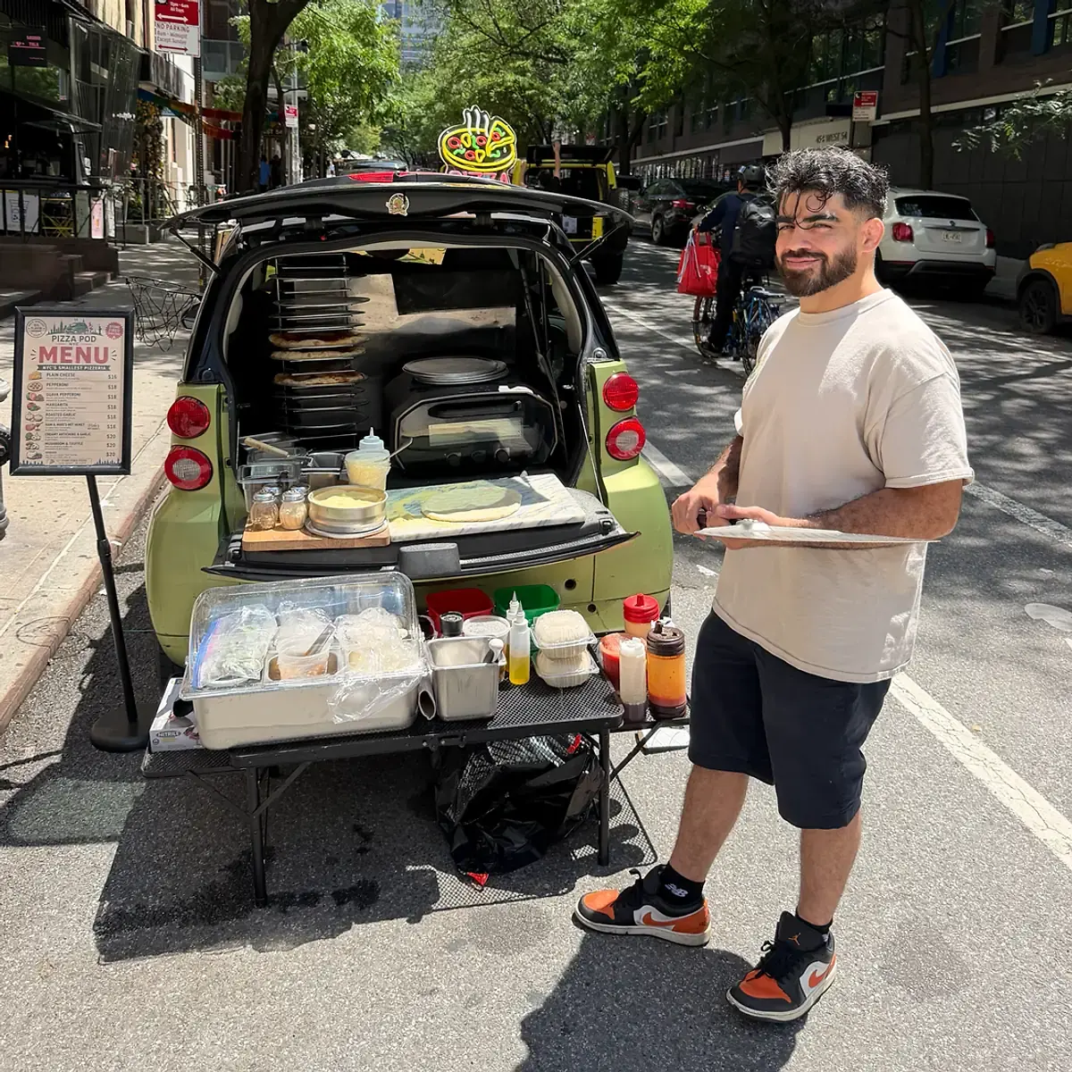 Bradley Alvelo at the Pod's open hatch, pie racks stacked behind him
