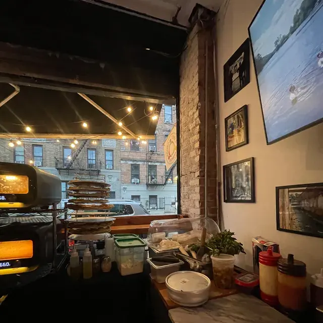 Two ovens set up inside a brick-walled bar, prep laid out along the counter